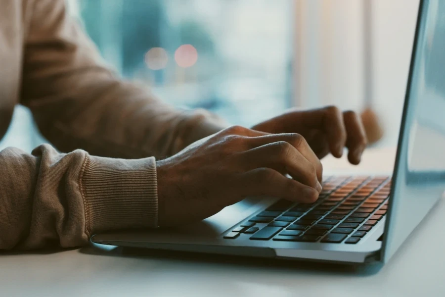 Person typing a message on a laptop