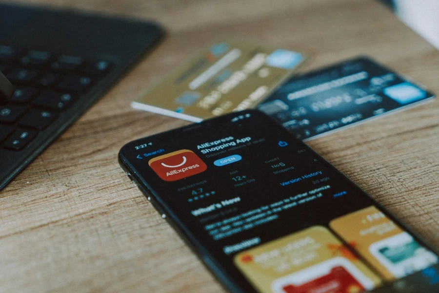 Phone sitting on a table showing homepage of AliExpress