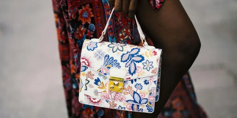 Foto di persona che tiene in mano una borsa floreale bianca