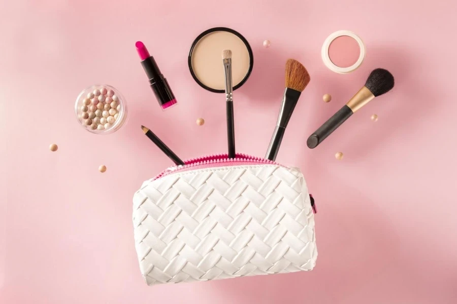 Professional make-up flying out of a bag, on a pink background