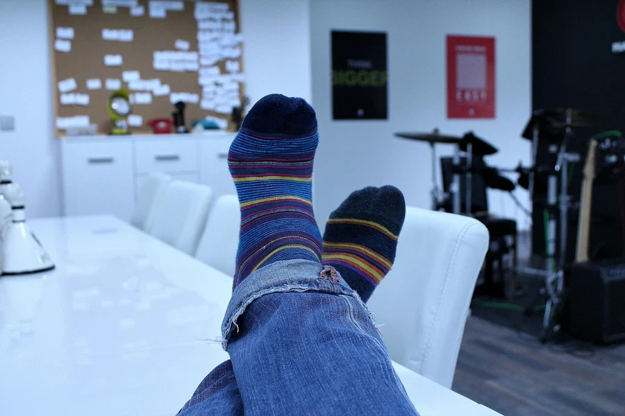 Relaxing in an office with colorful socks and blue jeans, showcasing casual comfort