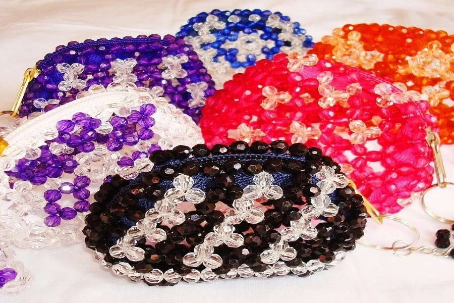 Several beaded bags on a table in different colors and designs