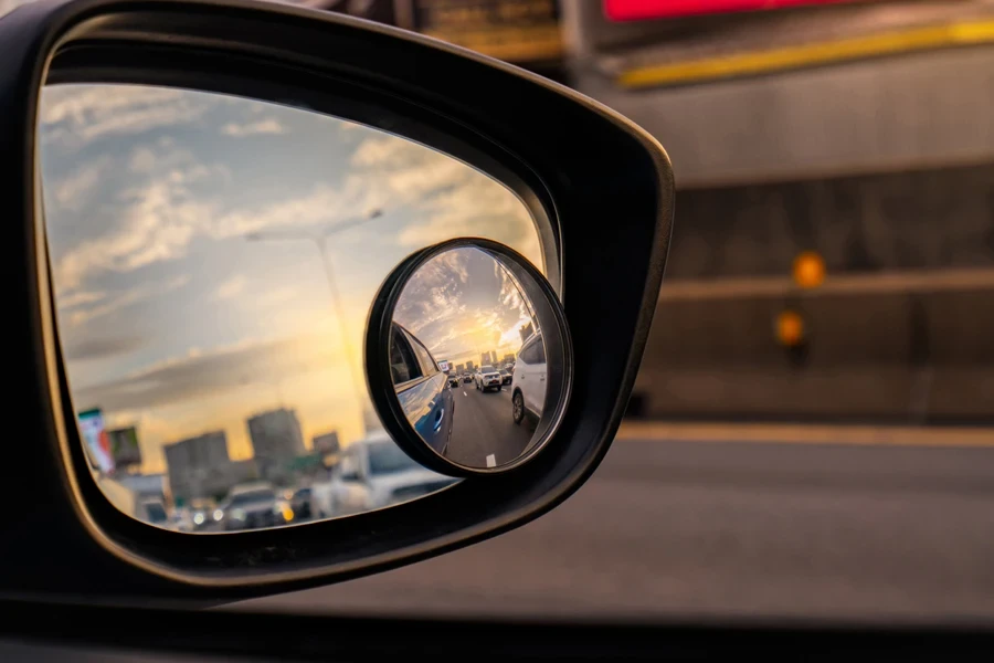 Side mirror of car while driving on highway