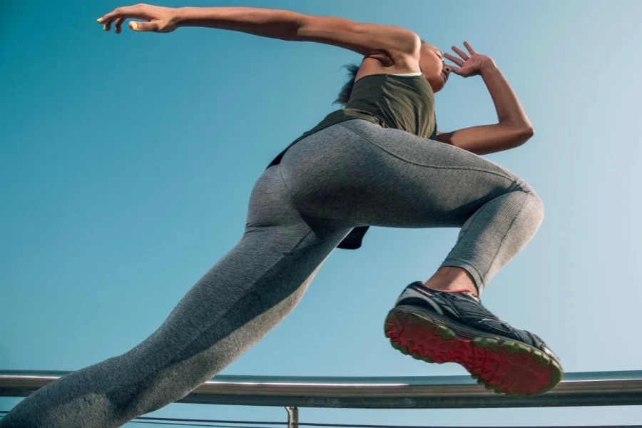 Slim fit athletic woman exercising while running stock photo