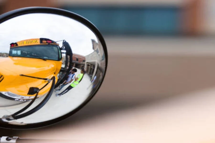 Small convex mirror attached to side of school bus