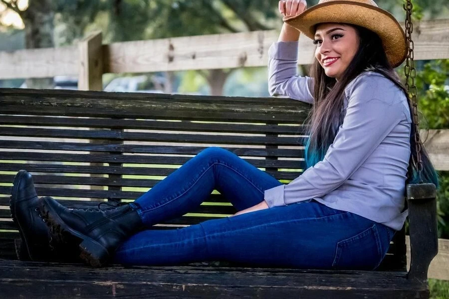 Smiling woman in a jeans-styled cowgirl outfit