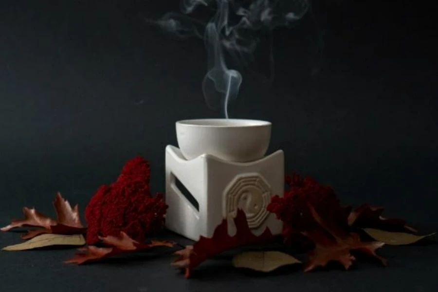 Smoke rising from white ceramic incense bowl