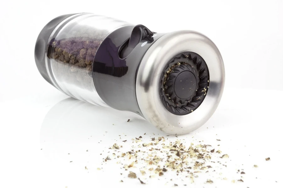 Stainless steel and glass pepper grinder laid flat