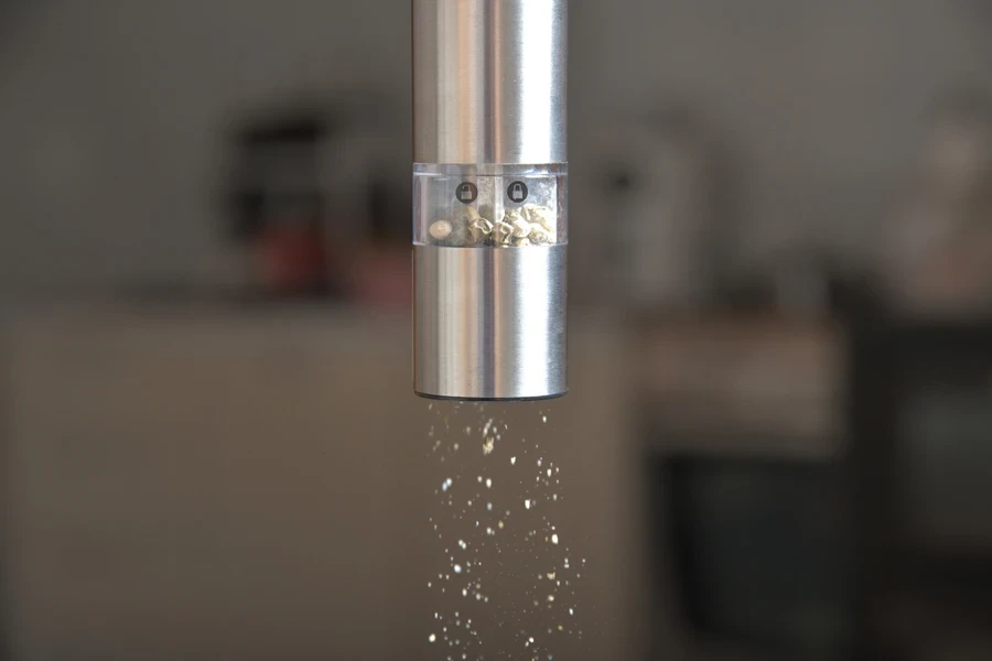 Stainless steel finish gravity-activated salt grinder used in home kitchen