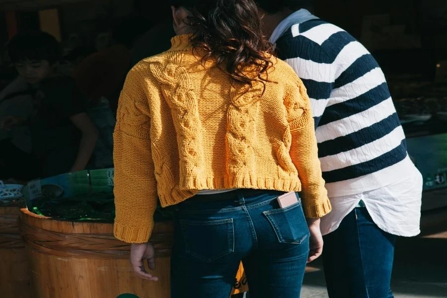 Two women wearing yellow and striped sweater