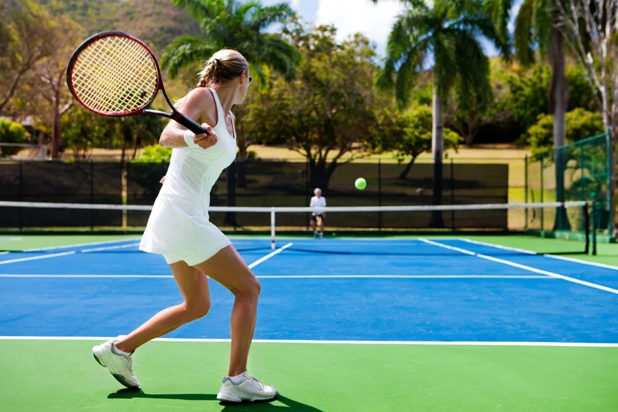 Woman hitting ball on court in the summer