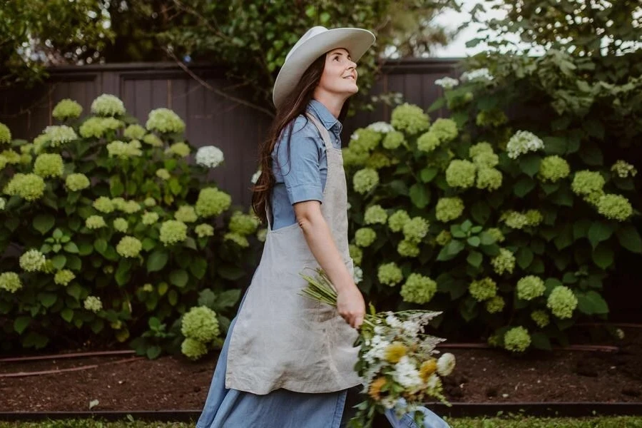 Woman in a cowgirl hat carrying flowers