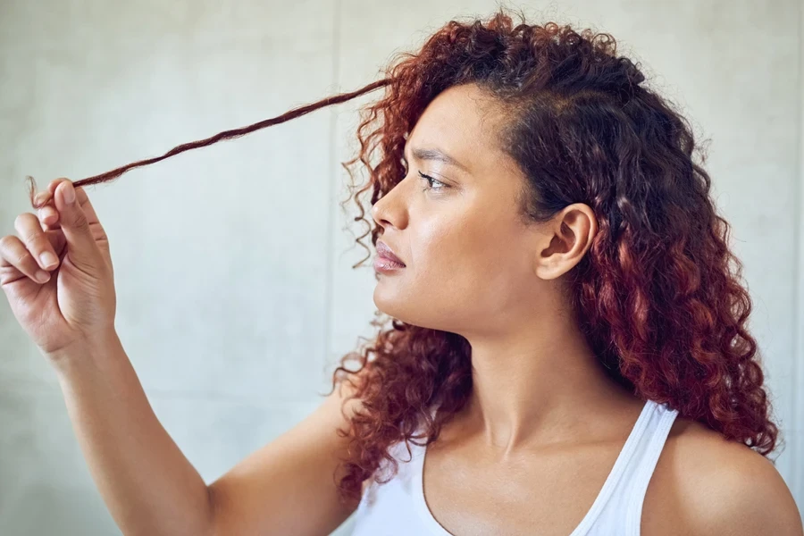 Woman looking at her hair with concern