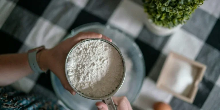 Wanita menggunakan ayakan baja tahan karat dengan bubuk tepung