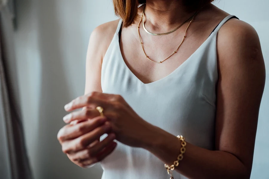 Woman wearing gold chain necklace and gold bracelet