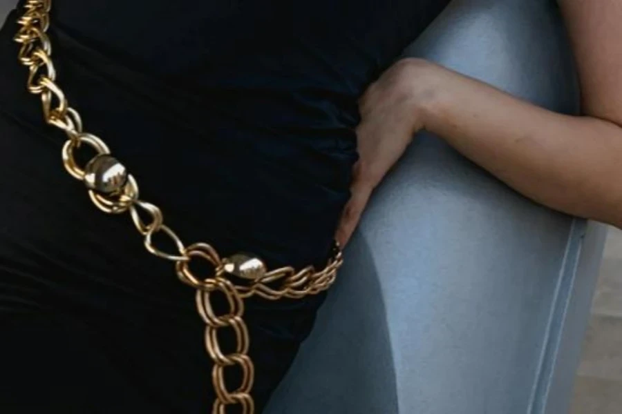 Woman wearing shiny gold chain belt