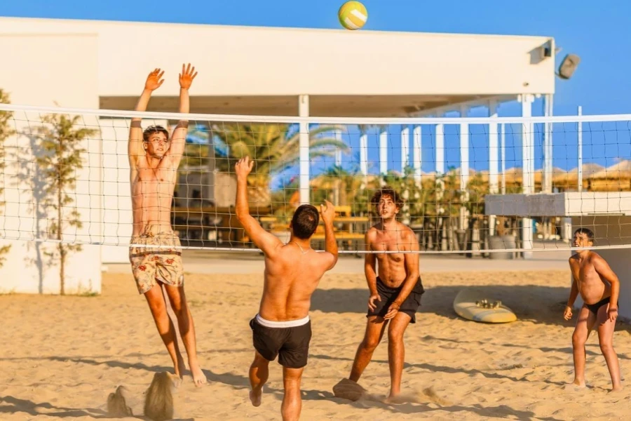 Young Caucasian men playing volleyball on the sand