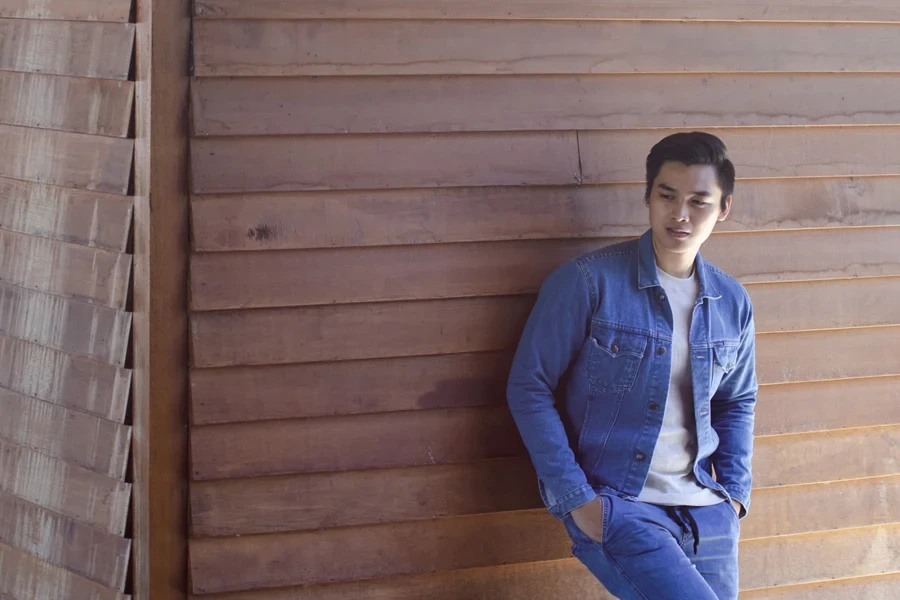 Young adult Asian male in denim jacket and pants
