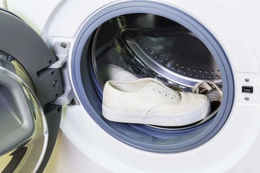 A dirty white sneaker in a washing machine