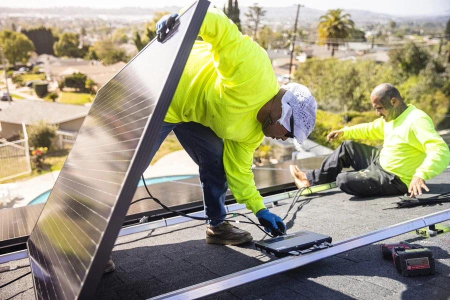 A man connecting solar panels to a microinverter