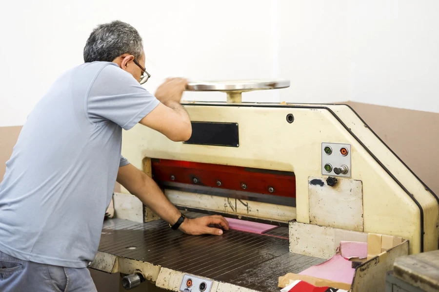 A man operating a die cutter