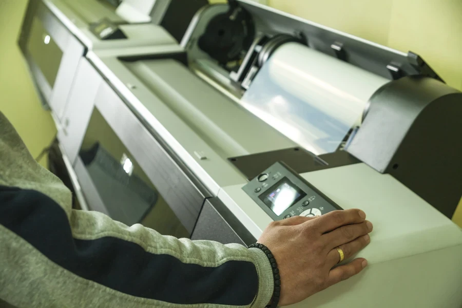 A man operating a large-format printer