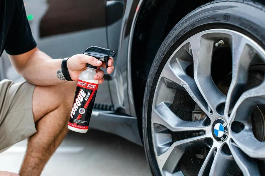 A man spraying a car wheel