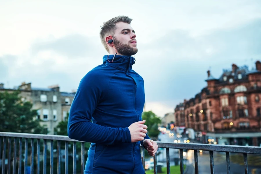 A man wearing a velour zip-up tracksuit