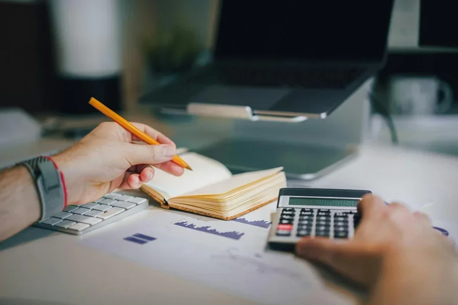 A person holding a pencil and a notebook