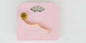 A pink scale with a measuring tape