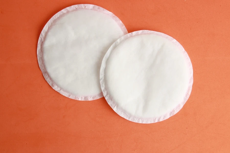 A set of white nipple covers on an orange background