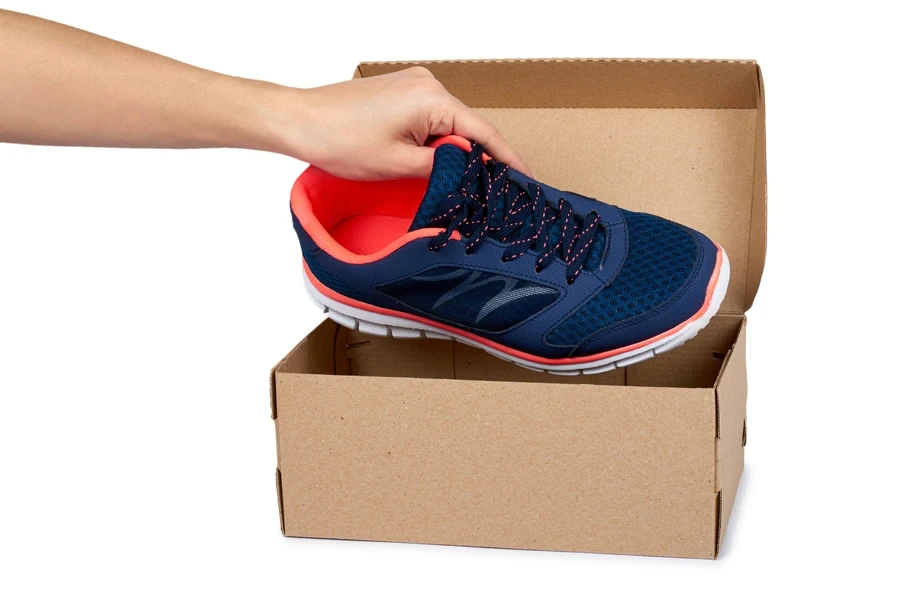 A wide-toe sneaker being brought out of its box