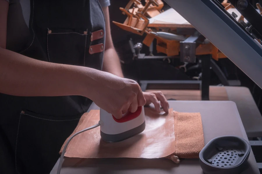 A woman pressing a design in her workshop