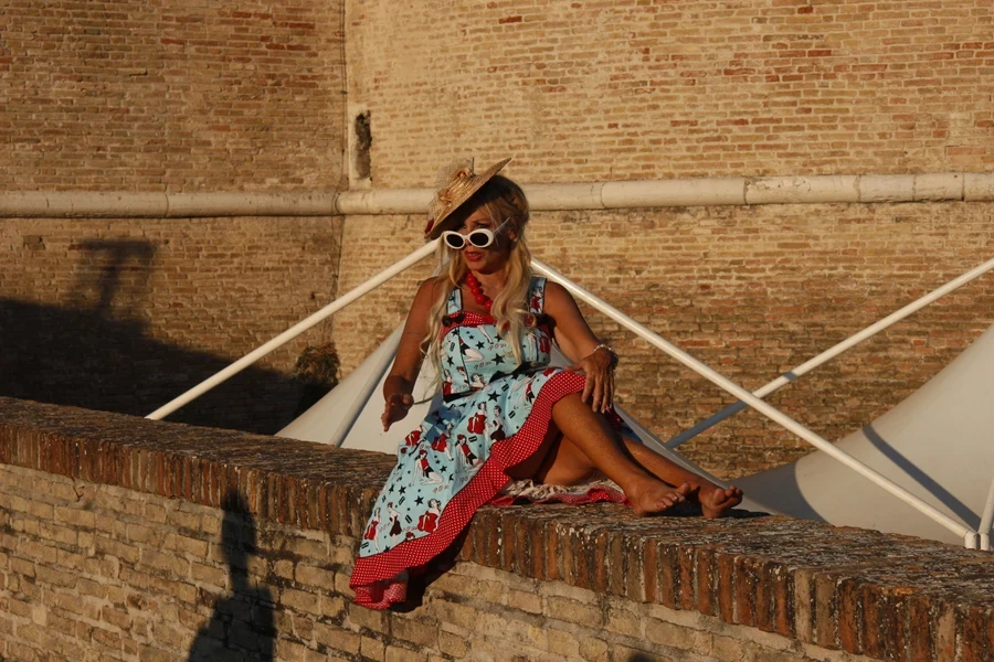 A woman sitting with a vintage print swing dress