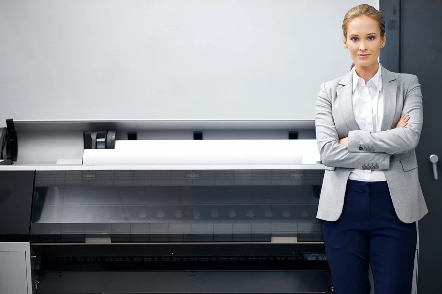 A woman standing next to a large-format printer