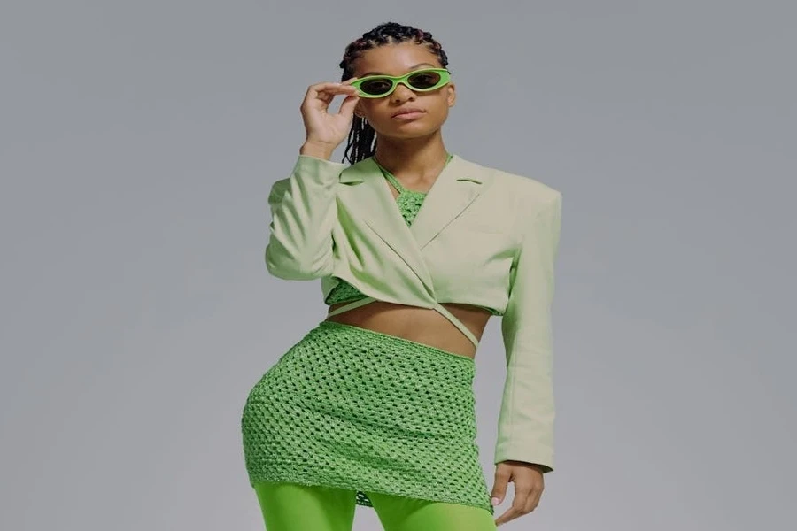 A young woman wearing a green cropped blazer