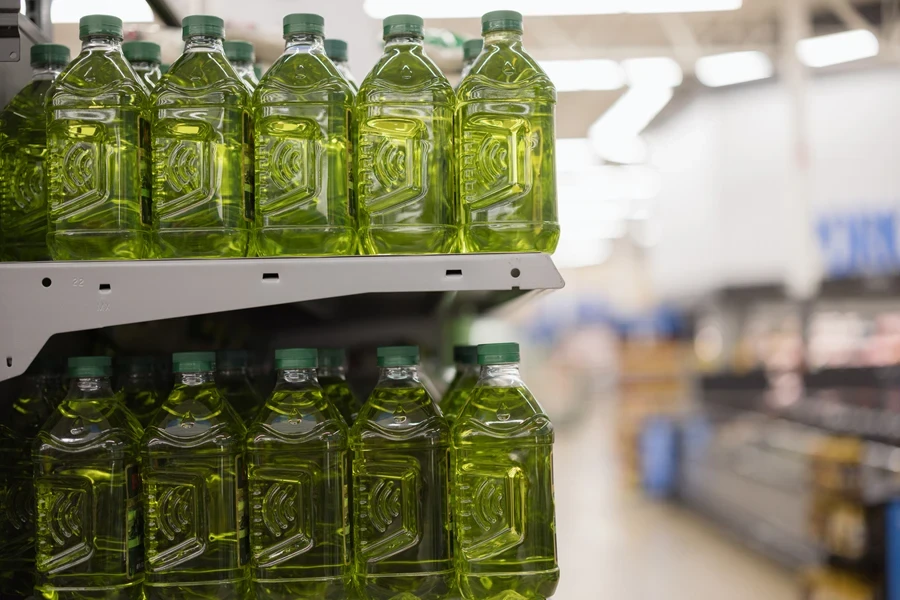 Aisle in supermarket with plastic bottles for oil without labels