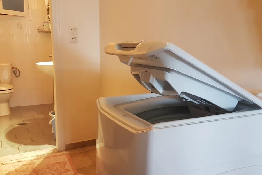 An open washing machine in a bathroom