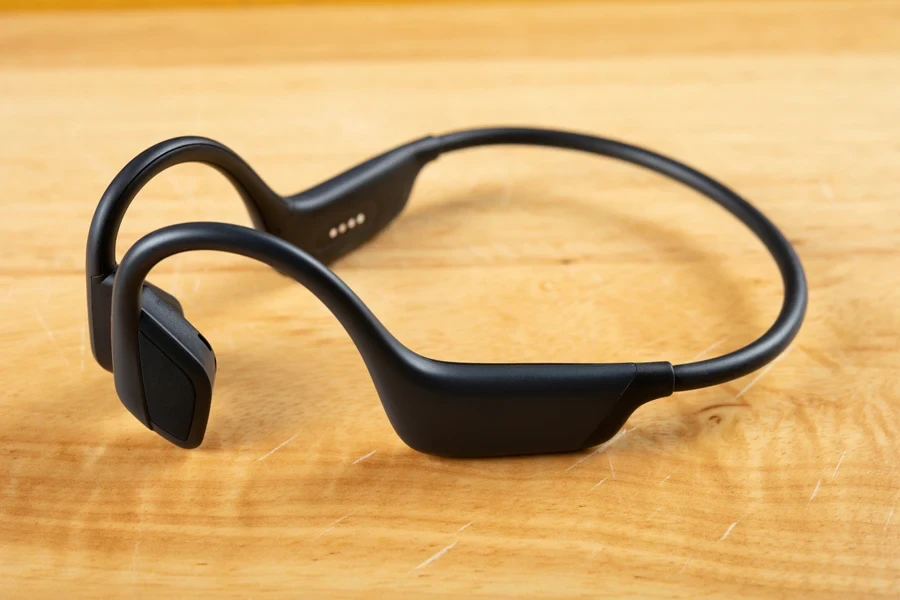 Black bone conduction headphones on a wooden table
