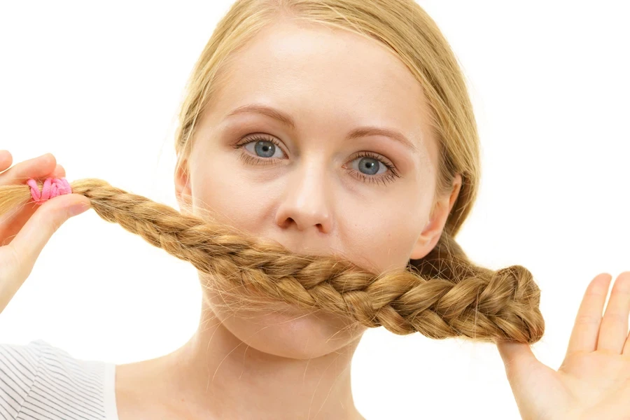 Blond girl showing Dutch braids in front of face