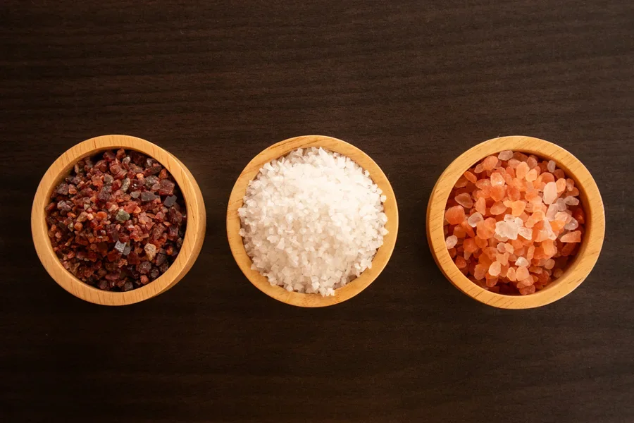 Coarse salt and spices in wooden bowls for perfect seasoning