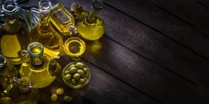 Collection of glass olive oil bottles on wooden table