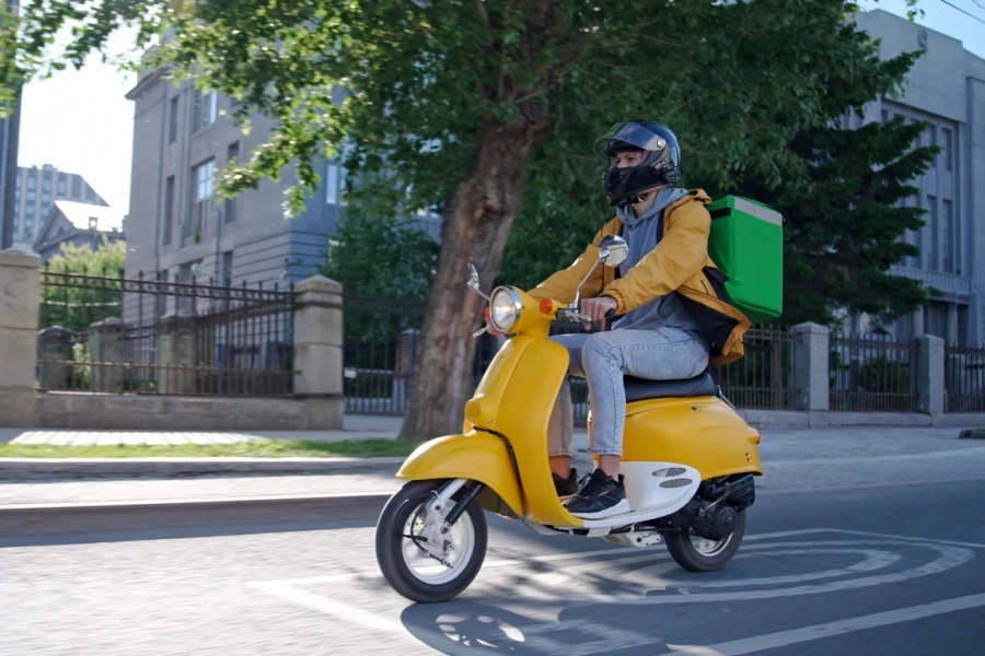 Delivery man riding on a scooter