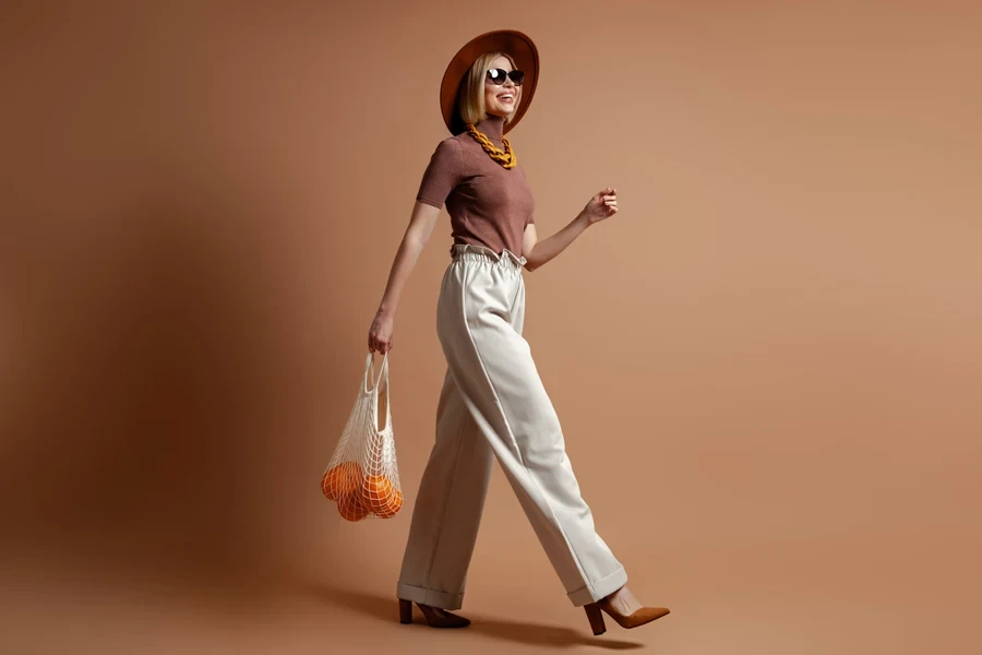 Fashionable woman in a wide-brimmed hat, drawstring pants, and heels