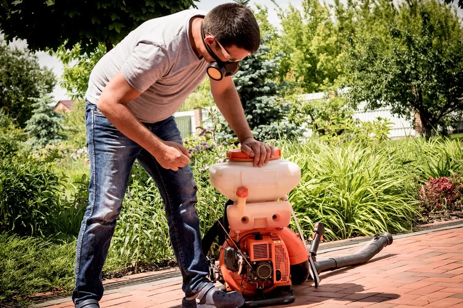 Gardener starting a backpack gas-powered leaf blower
