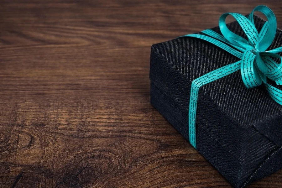 Gift box with bow on wooden table