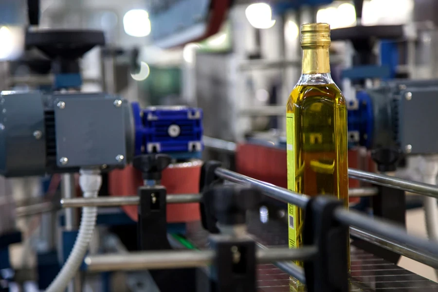 Glass olive oil bottle on production line at factory