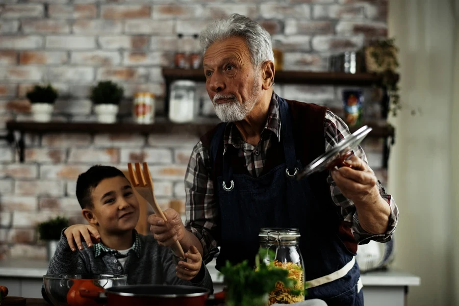 Grandfather and grandson preparing food in the kitchen