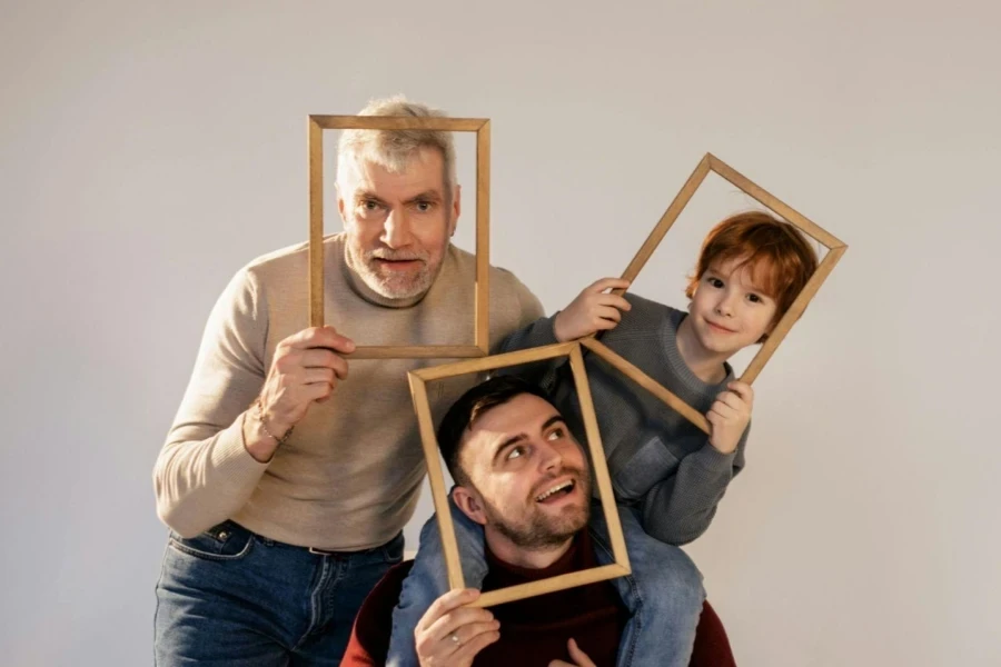 Grandpa, son, and grandson holding wooden photo frames