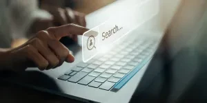 Hand using laptop and press screen to search Browsing on the Internet online.
